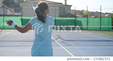 Woman in her 40s playing tennis on a sunny outdoor court 115862372