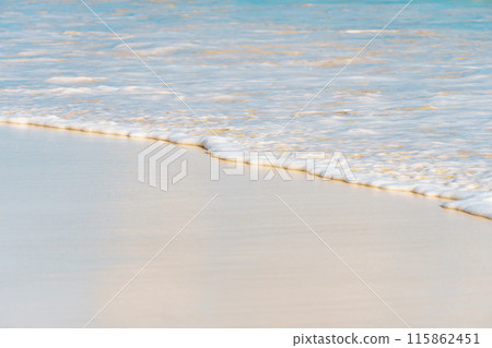 A detailed view of ocean waves crashing onto the sandy shore A detailed view of ocean waves crashing onto the sandy shore 115862451