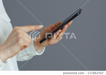 Stylish woman employee using phone isolated on grey Stylish woman employee using phone isolated on grey 115862587