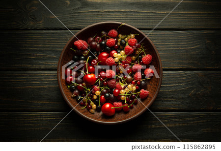 Vintage bowl on a dark table with ripe berries, currants, cherries, raspberries 115862895