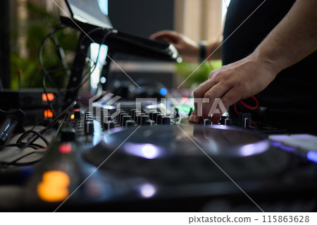 control DJ for mixing music with blurred people dancing at party in nightclub. control DJ for mixing music with blurred people dancing at party in nightclub. 115863628