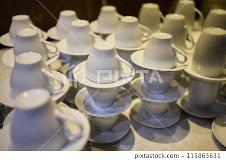 Neatly stacked white coffee cups for elegant events or catering, making a stylish presentation Neatly stacked white coffee cups for elegant events or catering, making a stylish presentation 115863631