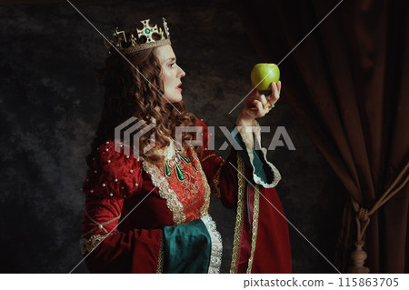 medieval queen in red dress with green apple and crown medieval queen in red dress with green apple and crown 115863705