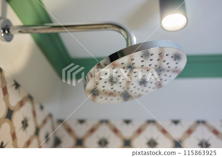Contemporary stainless steel showerhead in a bathroom, featuring modern design and function 115863925