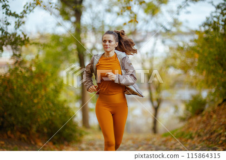 young female in fitness clothes in park running 115864315