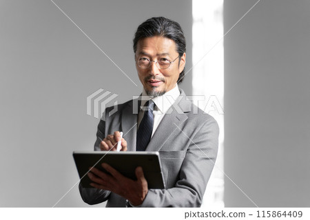 Senior businessman with tablet 115864409