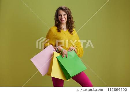 smiling trendy 40 years old woman isolated on green background smiling trendy 40 years old woman isolated on green background 115864500