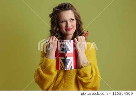 happy healthy woman in yellow sweater isolated on green happy healthy woman in yellow sweater isolated on green 115864509