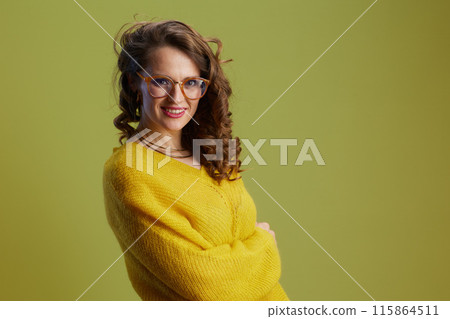 smiling trendy woman in sweater and glasses isolated on green smiling trendy woman in sweater and glasses isolated on green 115864511