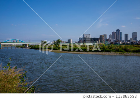 Riverside view of Japan's Tama River in Tokyo, overlooking the buildings of Musashi-Kosugi Riverside view of Japan's Tama River in Tokyo, overlooking the buildings of Musashi-Kosugi 115865558
