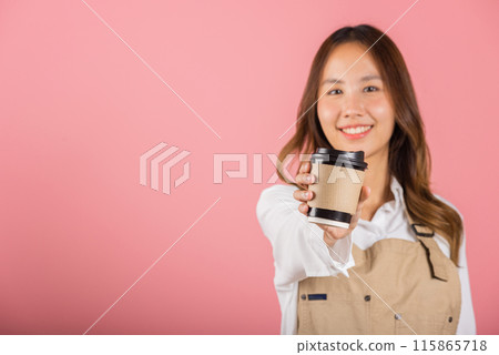 Portrait of Asian happy young woman barista bar tender coffee maker holding coffee tea hot cup studio shot isolated on pink background, female person smiling hold takeaways cup, small business Portrait of Asian happy young woman barista bar tender coffee maker holding coffee tea hot cup studio shot isolated on pink background, female person smiling hold takeaways cup, small business 115865718