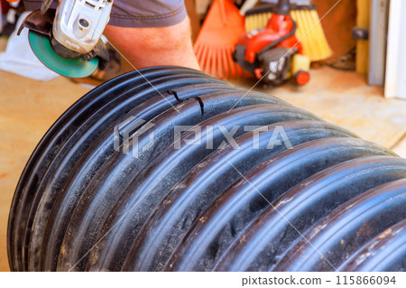 For purpose of connecting another pipe, hole was cut in black plastic polypropylene sanitary pipe 115866094