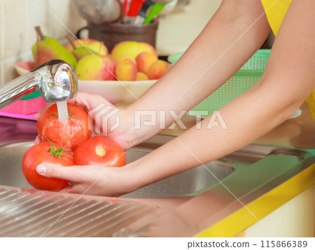 woman washing fresh vegetables in kitchen 115866389