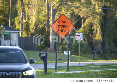 Warning roadworks sign and safety barrier on city street during maintenance repair work Warning roadworks sign and safety barrier on city street during maintenance repair work 115866418