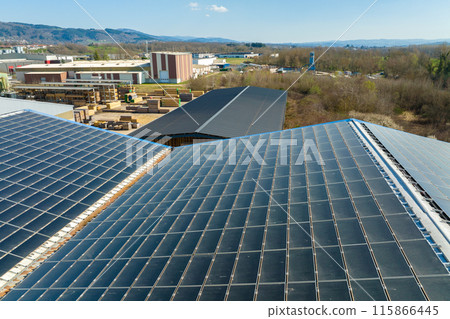 Aerial view of blue photovoltaic solar panels mounted on industrial building roof for producing green ecological electricity. Production of sustainable energy concept 115866445