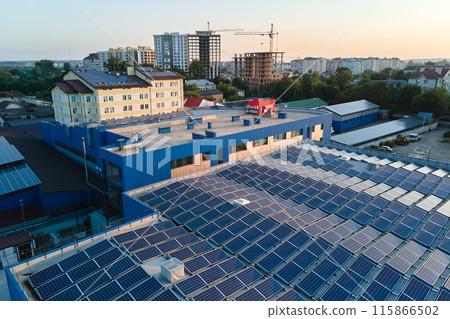 Aerial view of blue photovoltaic solar panels mounted on industrial building roof for producing green ecological electricity. Production of sustainable energy concept 115866502