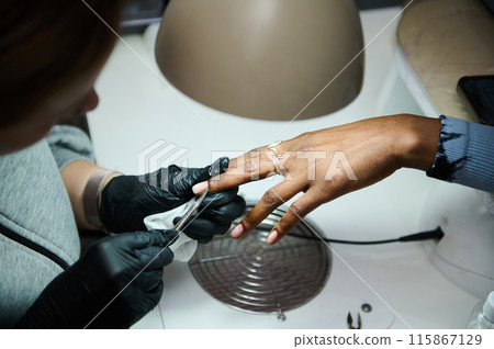 Manicure process at a beauty salon with client and professional Manicure process at a beauty salon with client and professional 115867129