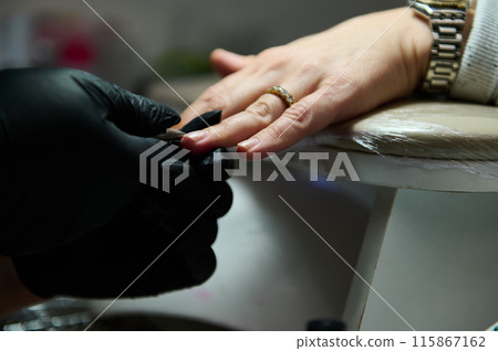 Manicure session in a beauty salon with client and professional 115867162
