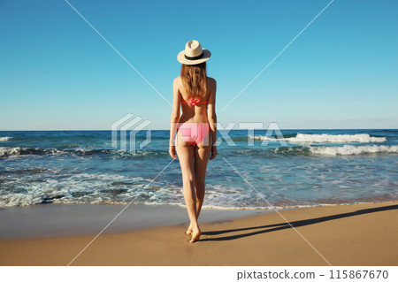Summer vacation, relaxed beautiful young woman in swimsuit, tourist hat on the beach on sea coast 115867670
