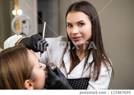 Young woman doing procedure of brow lamination at beauty salon.  115867695