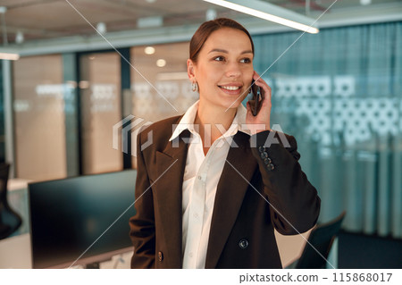 Successful businesswoman on phone in office, showing professionalism and confidence 115868017
