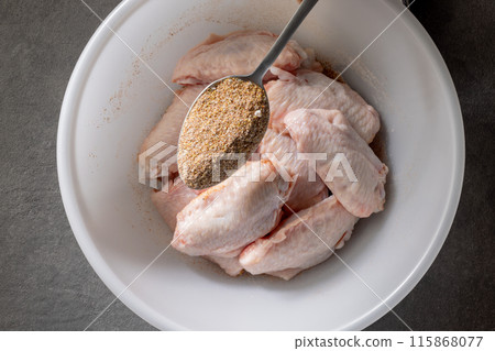 fresh raw chicken wings in bowl of spices fresh raw chicken wings in bowl of spices 115868077