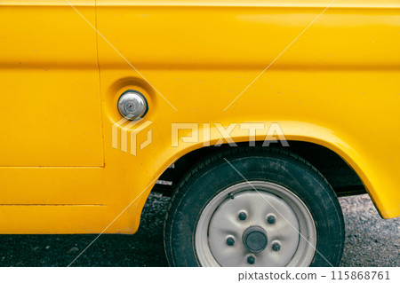 A yellow cars rear fender and wheel A yellow cars rear fender and wheel 115868761
