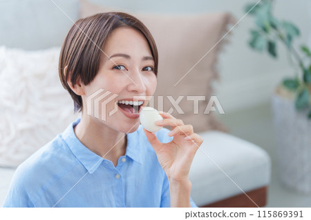 Woman eating boiled egg Woman eating boiled egg 115869391
