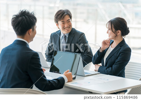 Smiling Asian businessman and businesswoman having a conference, meeting or business negotiation in a corporate office Smiling Asian businessman and businesswoman having a conference, meeting or business negotiation in a corporate office 115869486