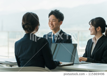 Smiling Asian businessman and businesswoman having a conference, meeting or business negotiation in a corporate office 115869496