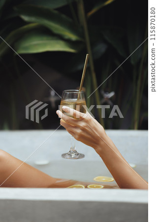 Relaxing in Citrus Bath with Wine Glass in Tropical Outdoor Setting Relaxing in Citrus Bath with Wine Glass in Tropical Outdoor Setting 115870180