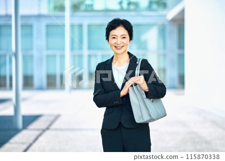 Middle business woman in a suit standing with a smartphone 115870338