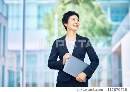 帶著微笑的筆記本電腦的中層女商人 115870716