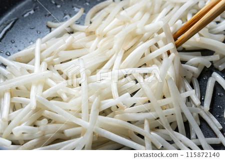 A cooking scene where bean sprouts are fried in a frying pan. A cooking scene where bean sprouts are fried in a frying pan. 115872140
