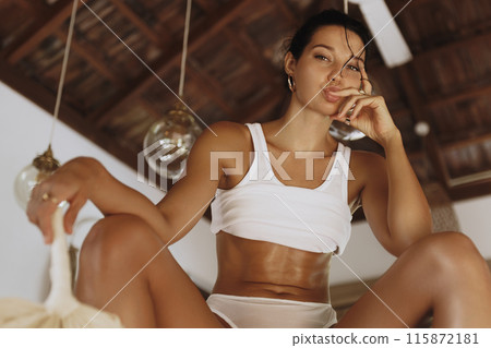 Sexy Woman in Minimal Attire Relaxing at Home in Stylish Setting 115872181