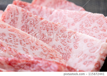 A close-up of a yakiniku beef platter, focusing on the triangular belly. 115872441