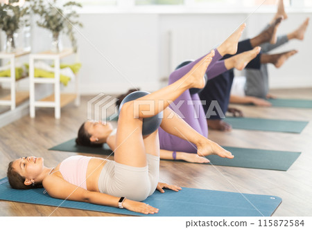 Girl coach shows students, holds fitball in lap and moves, shakes, shins, feet 115872584