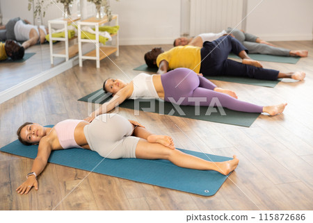 Group of men and women doing yoga in studio 115872686
