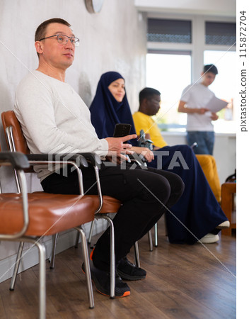 Man waiting for interview in lobby of job center Man waiting for interview in lobby of job center 115872704