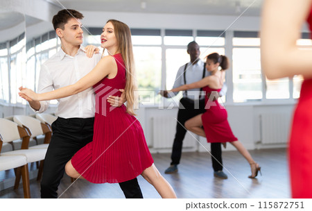 Young man and woman dancing tango in couple during lesson at studio 115872751