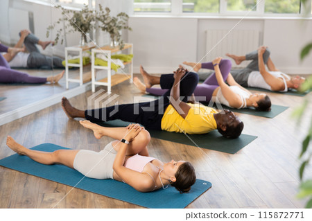 Young woman coach and students perform wind release during training in studio Young woman coach and students perform wind release during training in studio 115872771