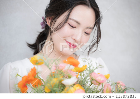 一位年輕女子拿著一束鮮花的美麗肖像,橙色和粉紅色的可愛春天般的形象 一位年輕女子拿著一束鮮花的美麗肖像,橙色和粉紅色的可愛春天般的形象 115872835