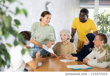 Group of multinational people discussing documents at table Group of multinational people discussing documents at table 115872914