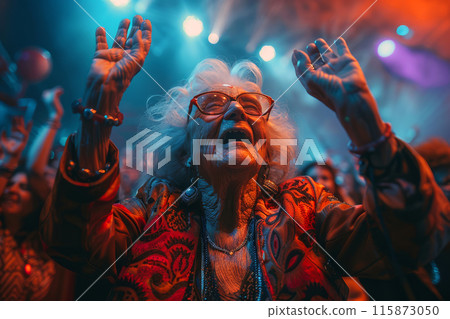 An elderly woman raises her arms in sheer joy, swaying to the beats at a vibrant concert under dazzling lights An elderly woman raises her arms in sheer joy, swaying to the beats at a vibrant concert under dazzling lights 115873050