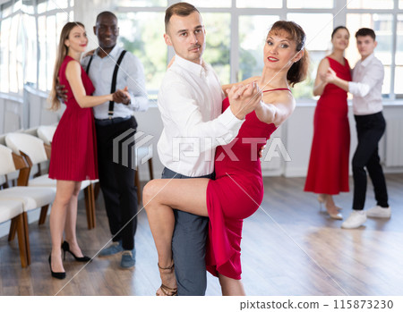 Young man and woman dancing tango in couple during lesson at studio 115873230