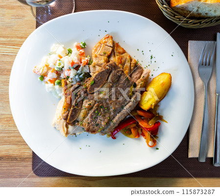 Grilled various meat served with stewed red peppers and salad 115873287