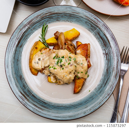 Dish of pork with Roquefort cheese sauce with potatoes 115873297