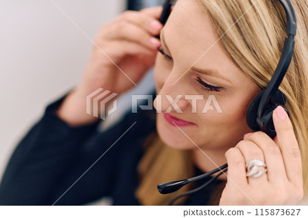 Friendly Call Center Agent Answering Incoming Calls with Headset Providing Remote Customer Service. 115873627
