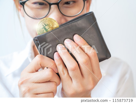 Happiness woman holding and looking leather wallet with a golden Bitcoin token in her hands. Bitcoin is one of the popular cryptocurrency, a virtual currency or a digital currency. Happiness woman holding and looking leather wallet with a golden Bitcoin token in her hands. Bitcoin is one of the popular cryptocurrency, a virtual currency or a digital currency. 115873719