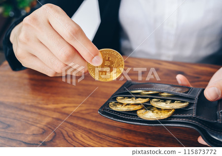 Close-up of businesswoman collect Bitcoin token in leather wallet. Bitcoin is one of the popular cryptocurrency, a virtual currency or a digital currency. Close-up of businesswoman collect Bitcoin token in leather wallet. Bitcoin is one of the popular cryptocurrency, a virtual currency or a digital currency. 115873772